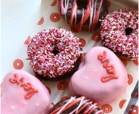 Chocolate and heart-shaped donuts inside a box.